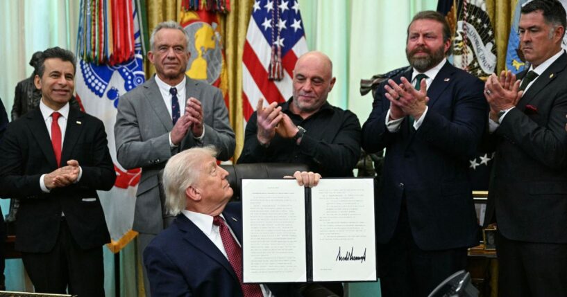FDA Commissioner Marty Makary, Health and Human Services Secretary Robert F. Kennedy Jr., media personality Joe Rogan, W. Bryan Hubbard, CEO of Americans for Ibogaine, and former Navy SEAL Marcus Lutrell applaud after President Donald Trump signed an executive order in the Oval Office of the White House in Washington, D.C., on April 18, 2026.