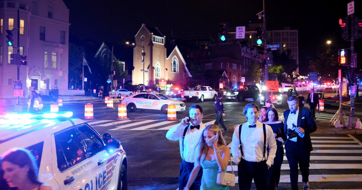 Guests walk away from the Washington Hilton amid a heavy police presence after shots were heard during the White House Correspondents' Dinner in Washington, D.C., on April 25, 2026.