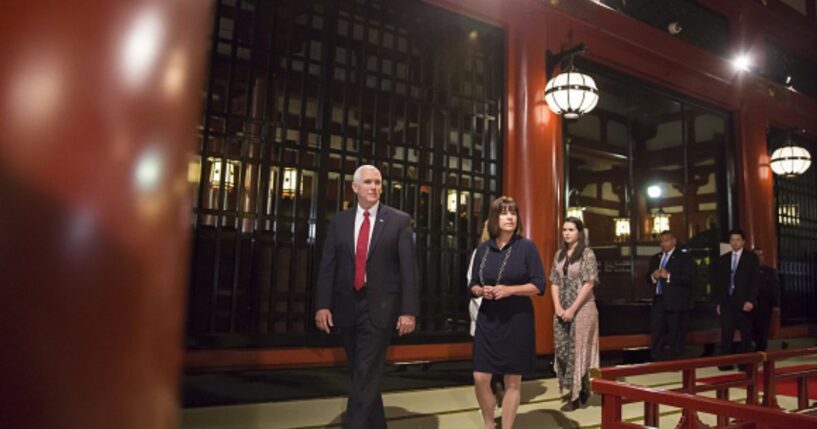 Mike Pence walks in Japan flanked by team members on April 18, 2017.