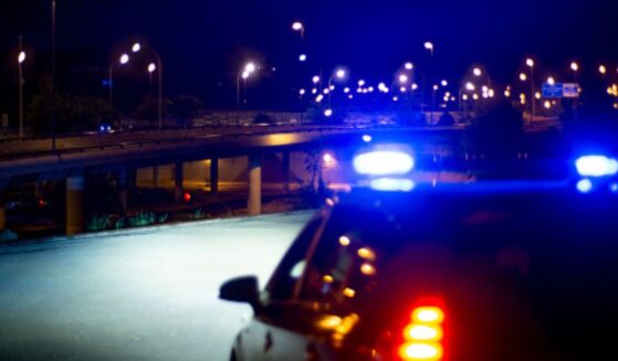 Cop lights flash as they park on a roadway.