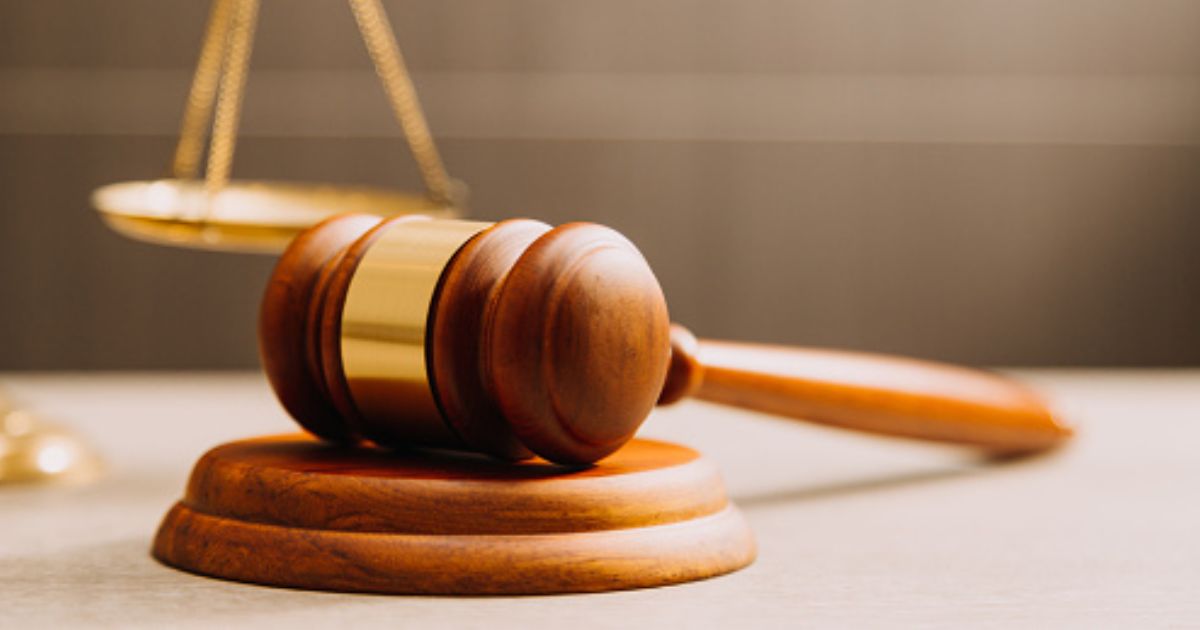 A gavel lays near a balancing scale.