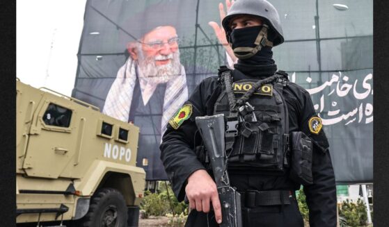 A member of the Iranian security forces stands guard next to a banner honoring Iran's slain supreme leader Ayatollah Ali Khamenei in Tehran on Tuesday.