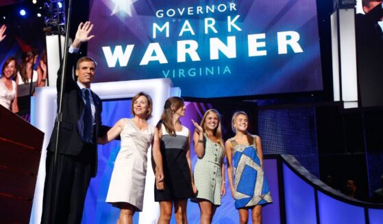 In a 2008 file photo, former Virginia Gov. Mark Warner waves from the stage with his wife, Lisa Collis, and daughters Eliza, Gillian, and Madison during day two of the Democratic National Convention in Denver, Colorado.