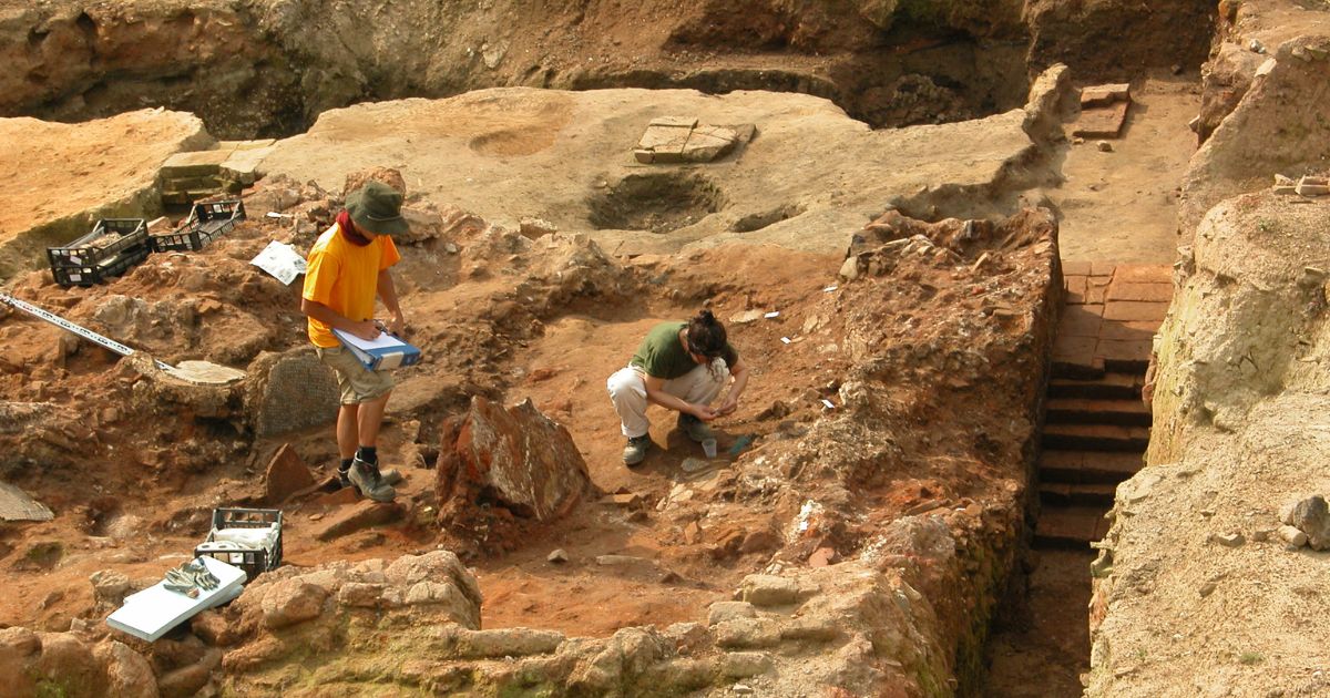 A stock photograph of two archeologists at work at a dig site.
