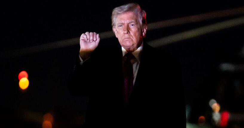 President Donald Trump holds up a fist as he exits Air Force One at Joint Air Base Andrews, Maryland, on March 29, 2026.