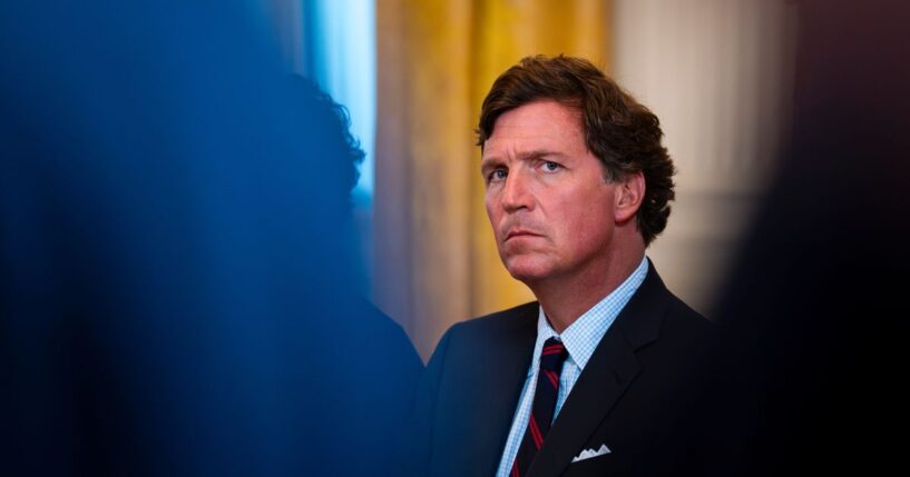 Former Fox News host Tucker Carlson looks on at a meeting with oil executives in the East Room of the White House on Jan. 8, 2026 in Washington, DC.