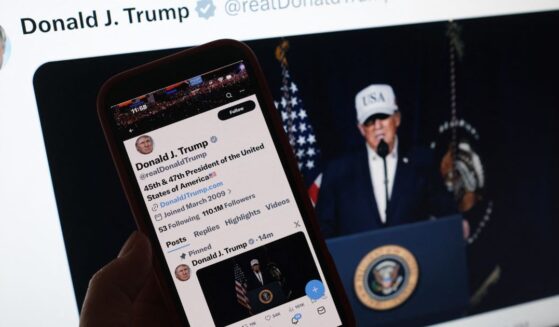 A person looks at President Donald Trump's social media accounts on a computer screen and a phone screen at the same time on Feb. 28, 2026.