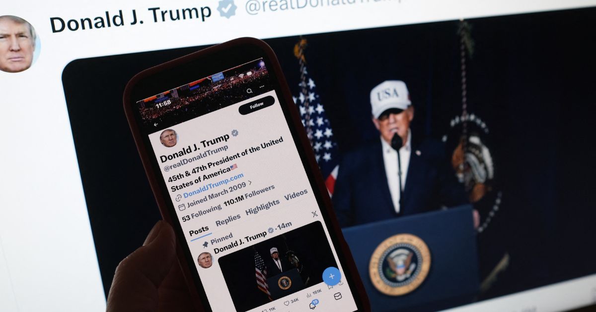 A person looks at President Donald Trump's social media accounts on a computer screen and a phone screen at the same time on Feb. 28, 2026.