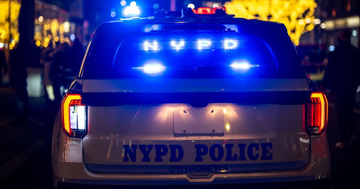 A New York City Police Department night patrol car stops in traffic.
