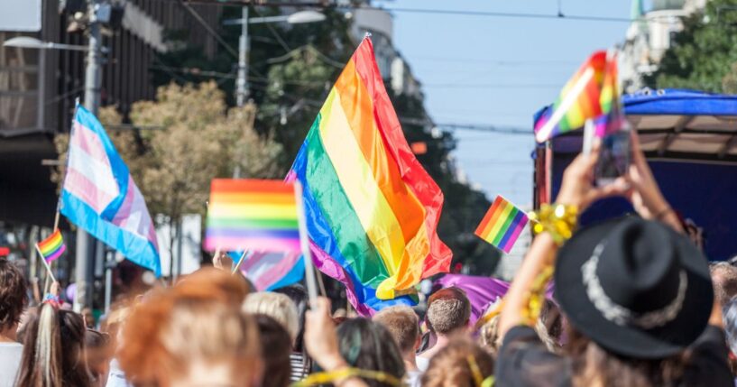 A picture of a crowd holding up LGBT flags during a gay pride parade.