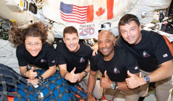 The Artemis II crew pose for. a photograph inside the Orion spacecraft on their way home from the far side of the Moon on April 6, 2026.