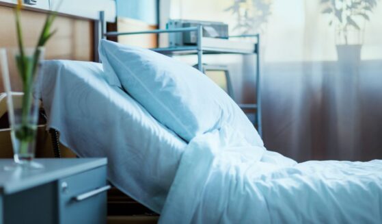 A side view of an empty hospital bed in a clinic.
