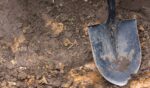 A close-up of a shovel in the dirt.