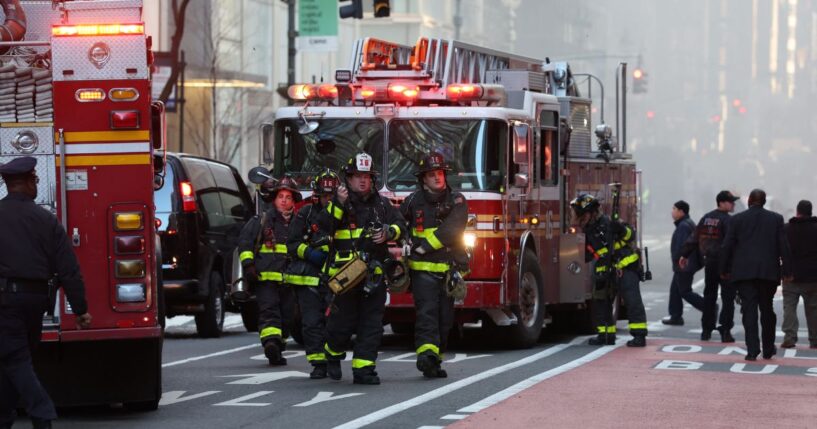 Firefighters from the New York City Fire Department workout the scene of the fire amidst heavy smoke in Midtown Manhattan on March 17, 2026.