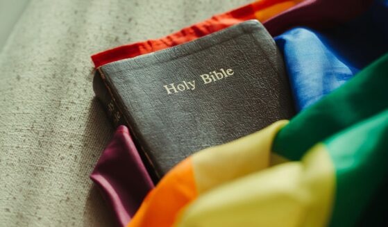 The Holy Bible wrapped in a rainbow-colored flag.