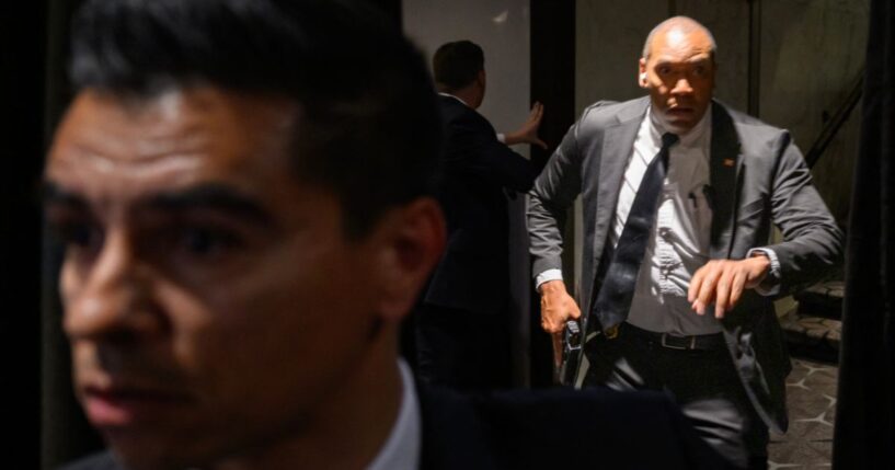 Agents draw their guns at the White House Corresondents' dinner at the Washington Hilton in Washington, DC after shots are fired on April 25, 2026.
