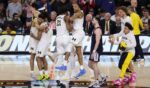 The Michigan Wolverines celebrate after defeating the UConn Huskies 69-63 in the National Championship of the 2026 NCAA Men's Basketball Tournament Monday in Indianapolis, Indiana.