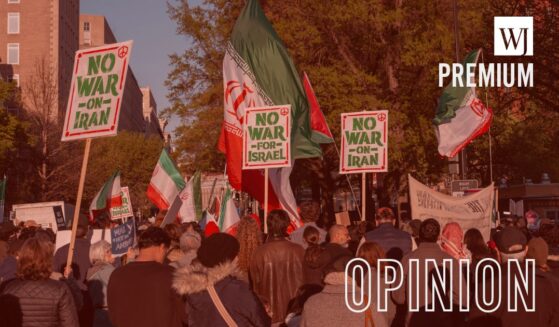 Protesters in opposition to the war with Iran carry signs and Iranian flags as they gather April 7 outside of Lafayette Park across from the White House in Washington, D.C.