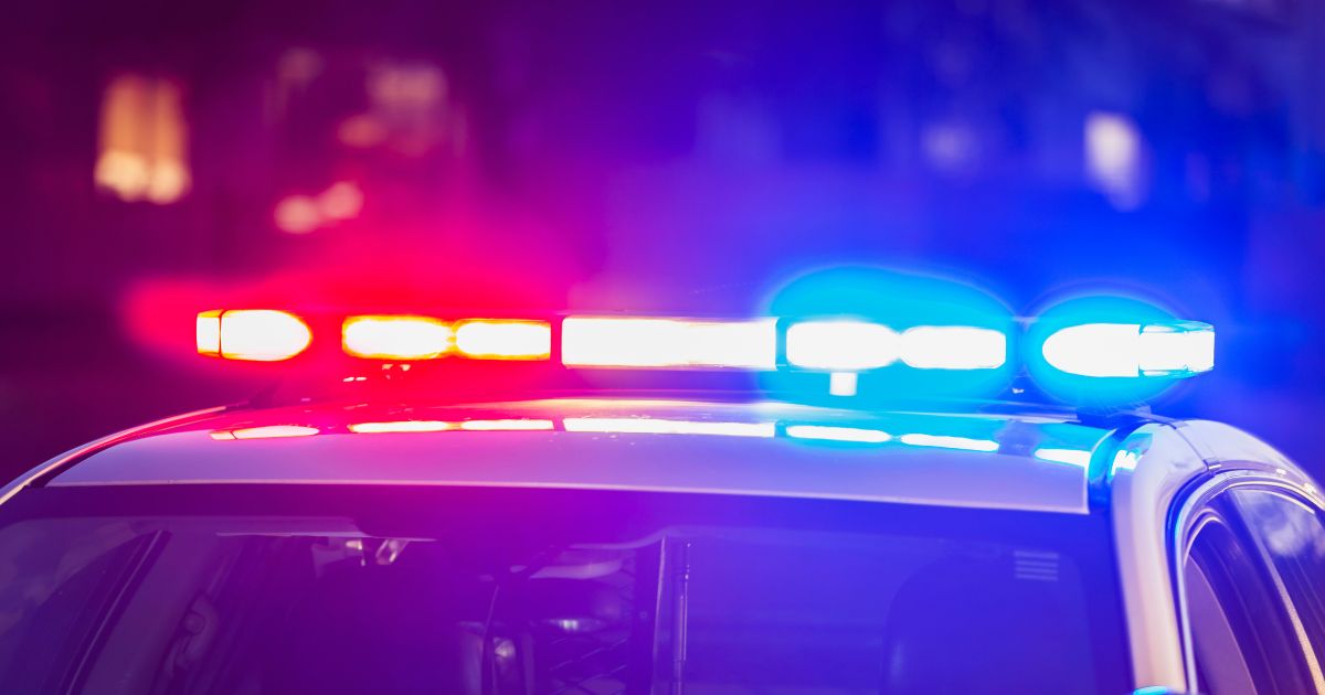 The roof of a police patrol car at night, with the blue and red lights flashing.