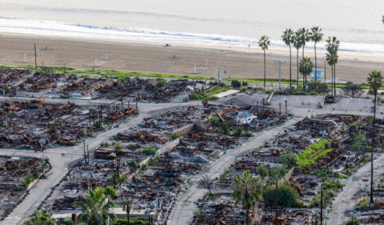 An American flag and sand bag stands on a cliff overlooking the remains of the Pacific Palisades Bowl Mobile Estates, which was destroyed in the 2025 Palisades fire, on the one year anniversary in Pacific Palisades on Jan. 6, 2026.