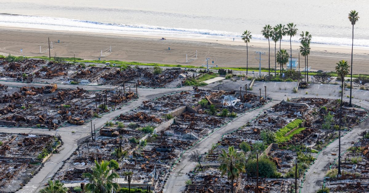 An American flag and sand bag stands on a cliff overlooking the remains of the Pacific Palisades Bowl Mobile Estates, which was destroyed in the 2025 Palisades fire, on the one year anniversary in Pacific Palisades on Jan. 6, 2026.