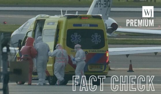 People in hazmat suits escorting an individual believed to be infected with hantavirus into a medical vehicle in Spain's Canary Islands on May 6, 2026.