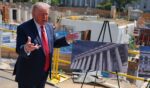 President Donald Trump speaks to the media Tuesday alongside posters of his proposed White House ballroom amid construction at the White House in Washington, D.C.