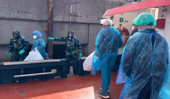 Passengers dressed in masks, plastic suits, and head coverings are escorted off the hantavirus-stricken cruise ship MV Hondius Sunday at the port of Granadilla in Tenerife, Canary Islands, Spain.