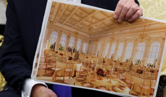 President Trump sits in the Oval Office and shows plans for the White House ballroom on October 22, 2025.