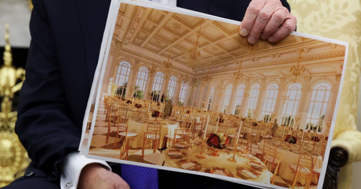 President Trump sits in the Oval Office and shows plans for the White House ballroom on October 22, 2025.