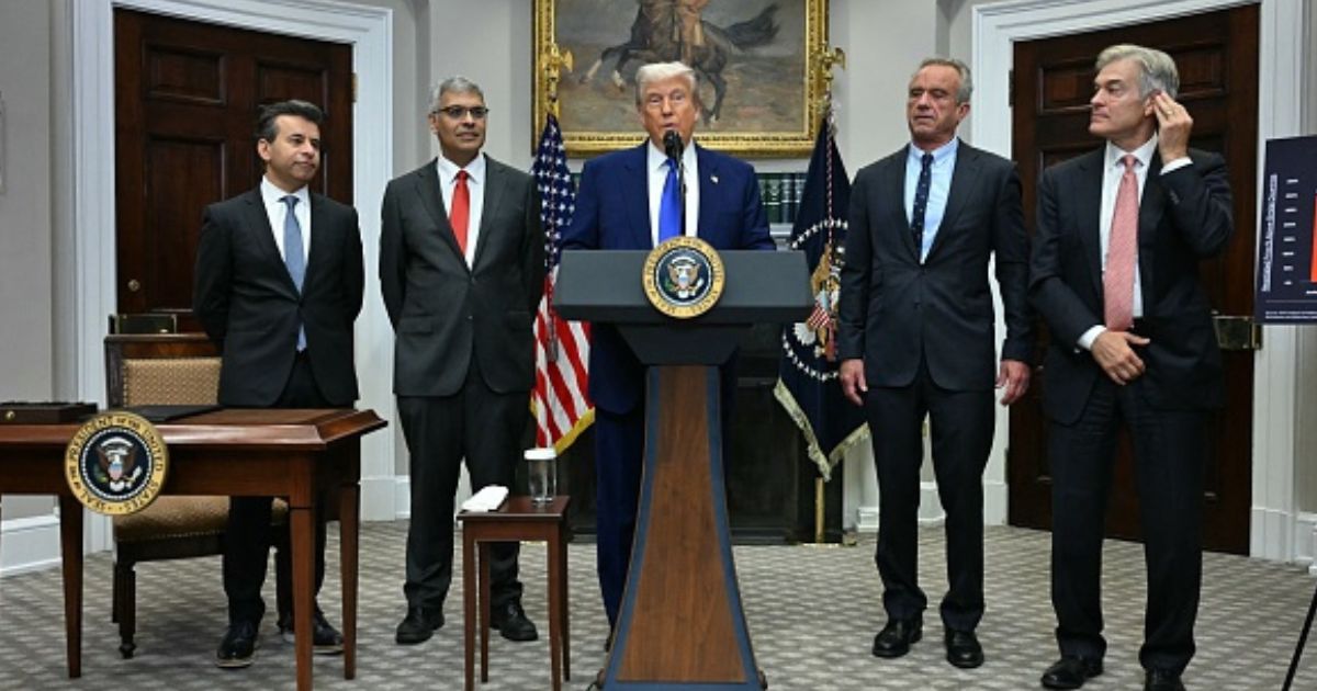 President Trump stands with administration officials such as Secretary of HHS Kennedy, FDA Commissioner Makary, and others on May 12, 2026.