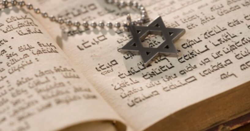 A Star of David medallion sits on a Torah.