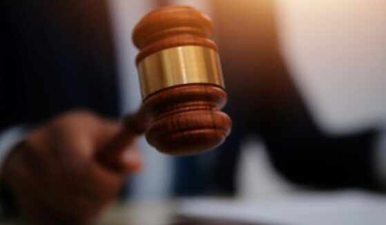 Man slams gavel on a wooden block.