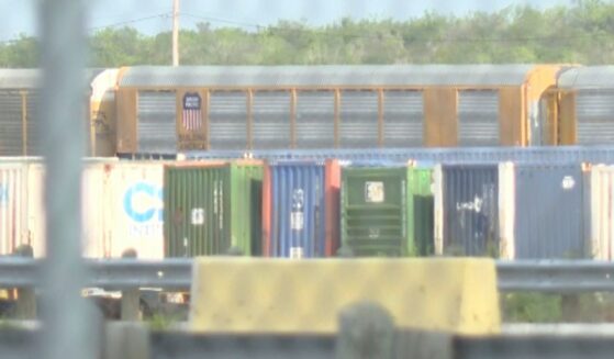 Union Pacific train cars can be spotted through a gate stationed at the rail yard in Laredo, Texas.