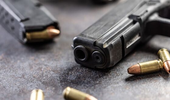 Guns and bullets lay on a table.