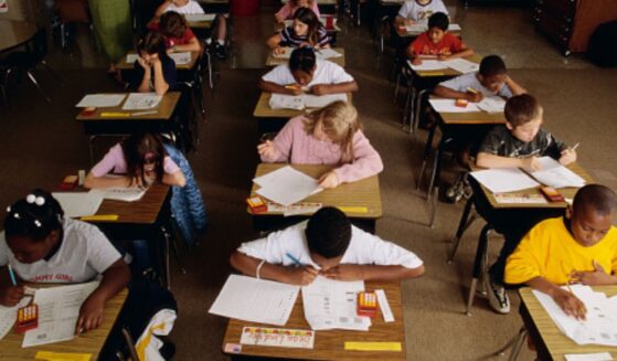 Students sit in a classroom and complete schoolwork.
