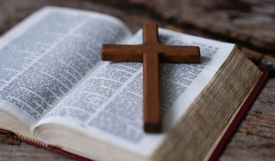 Crucifix sits at an angle on an opened Bible.