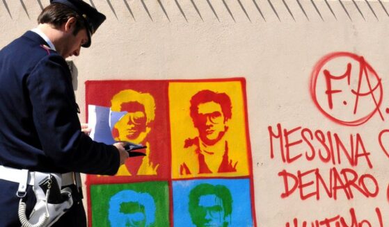 An Italian officer takes notes on graffiti of Matteo Messini Denaro on April 24, 2008.