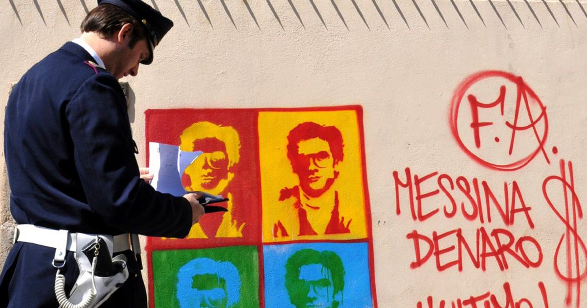 An Italian officer takes notes on graffiti of Matteo Messini Denaro on April 24, 2008.