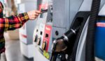 A person pays for gas at a gas station pump using a card.