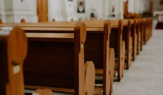 Rows of empty pews inside a church.