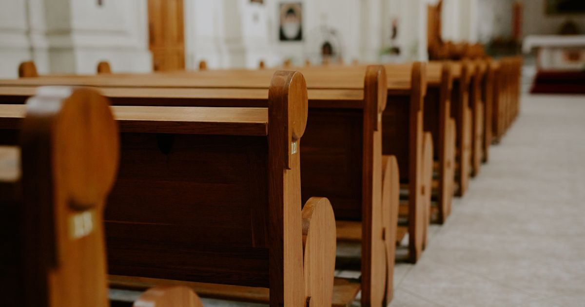 Rows of empty pews inside a church.