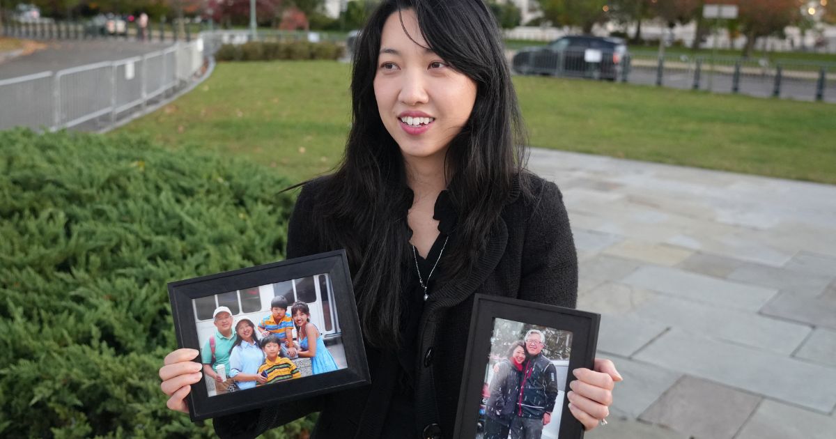 Grace Jin Drexel, the daughter of detained Chinese pastor Jin Mingri, holds up framed photos of Mingri and his family in Washington, DC on Oct. 30, 2025.