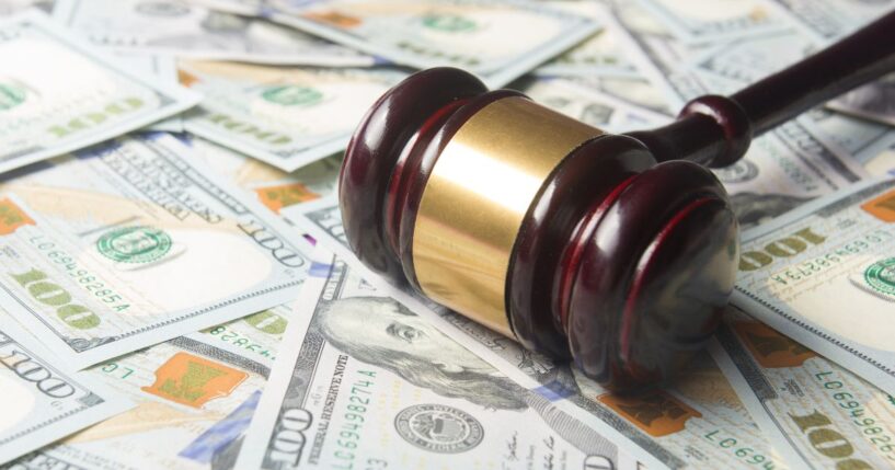 A gavel sits on a pile of cash.