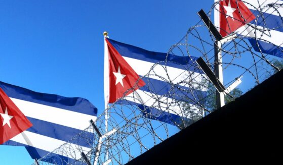 The Cuban flag flies above the walls of a prison.