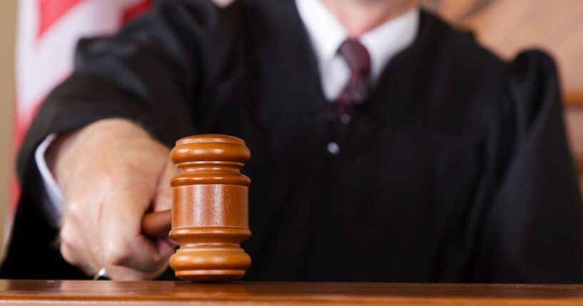 A close-up image of a judge holding a gavel.
