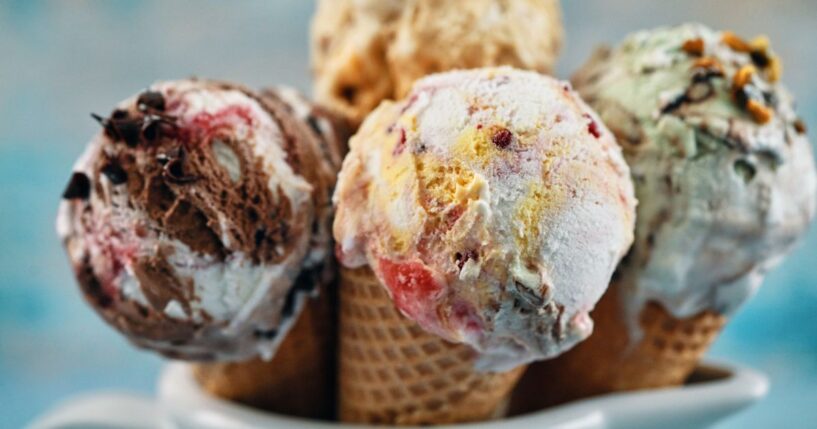 A variety of ice cream flavors in cones.