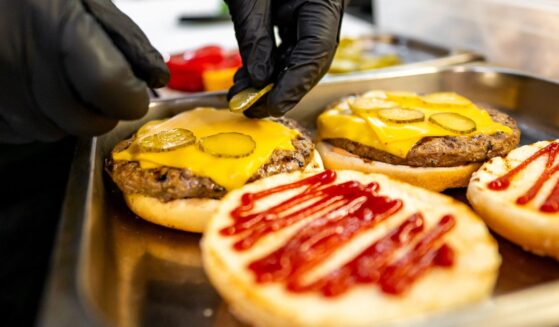 Close-up of hands assembling a fast food burger.
