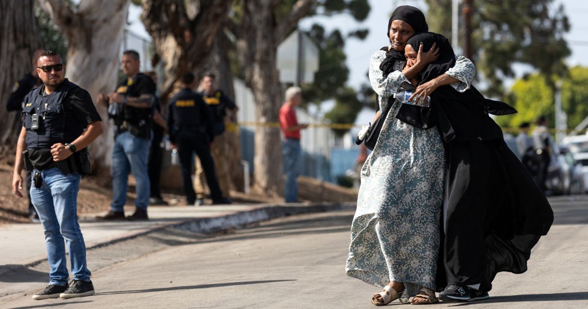 Two women react as they leave a reunification center following the shooting at the Islamic Center of San Diego in southern California Monday.