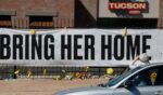 A person takes a photo of a Nancy Guthrie memorial on March 3 in front of the KVOA-TV station in Tucson, Arizona.